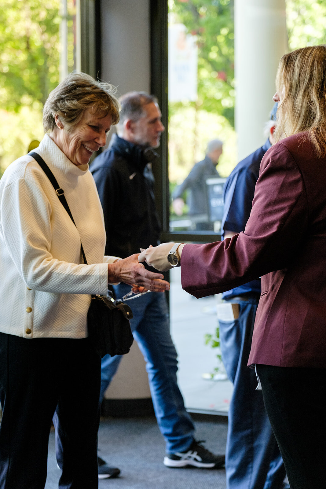 A smiling concertgoer is welcomed at the entrance to a Boise Phil performance.