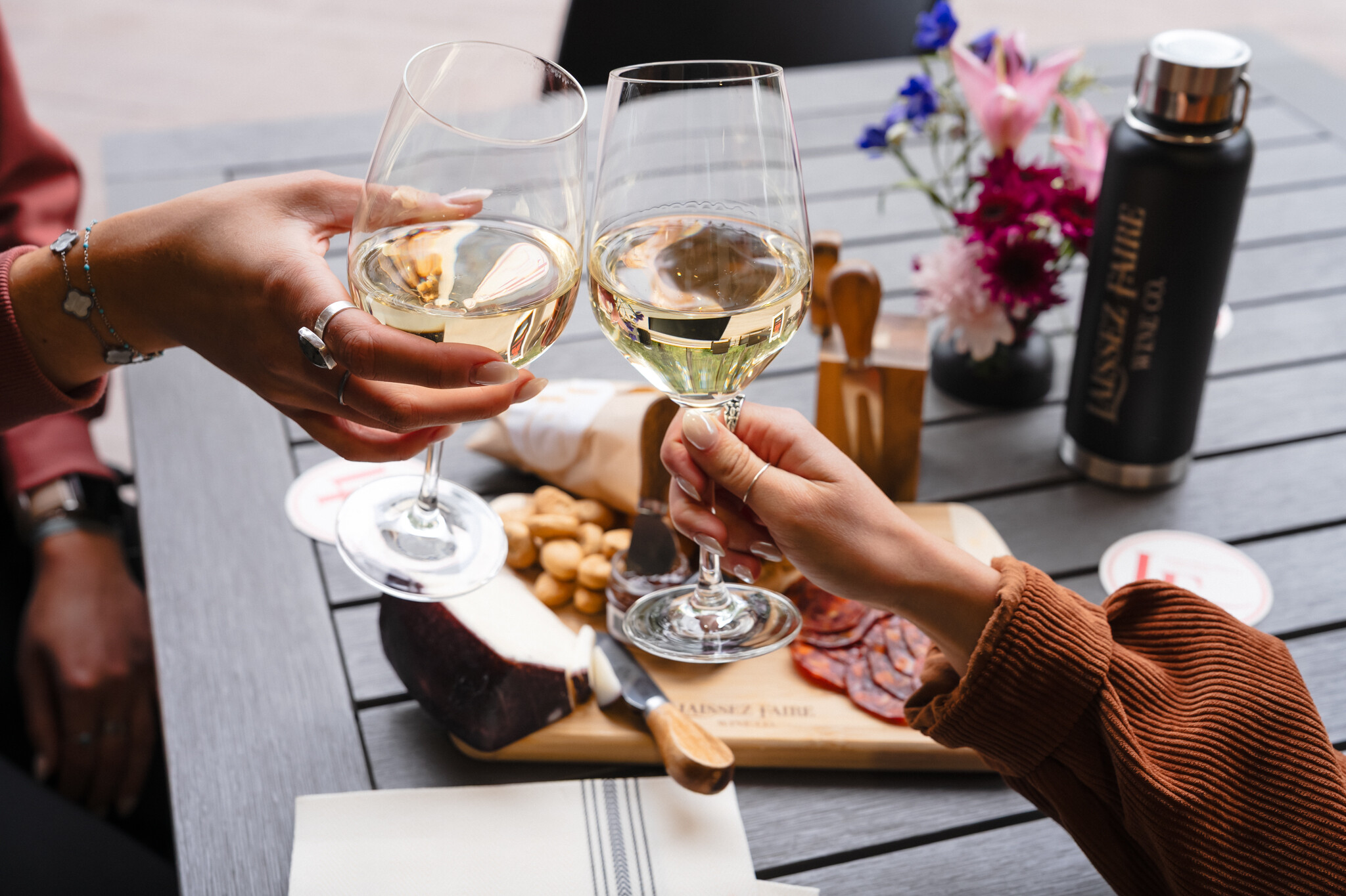 Wine glasses raised in a toast outdoors.