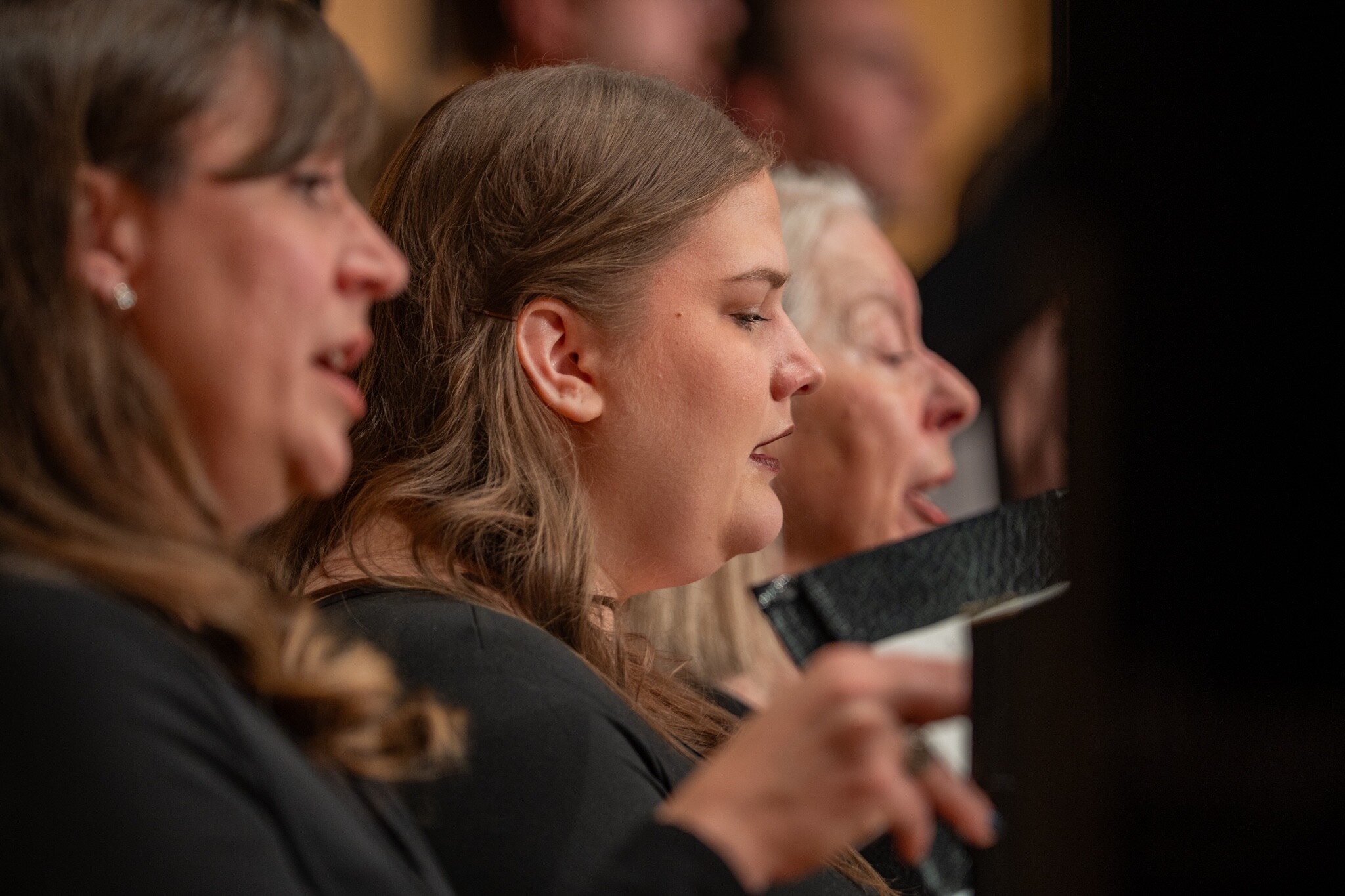 Boise Phil Master Chorale singers perform with open music folders.
